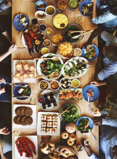 A long table seen from above, covered end to end with shared dishes