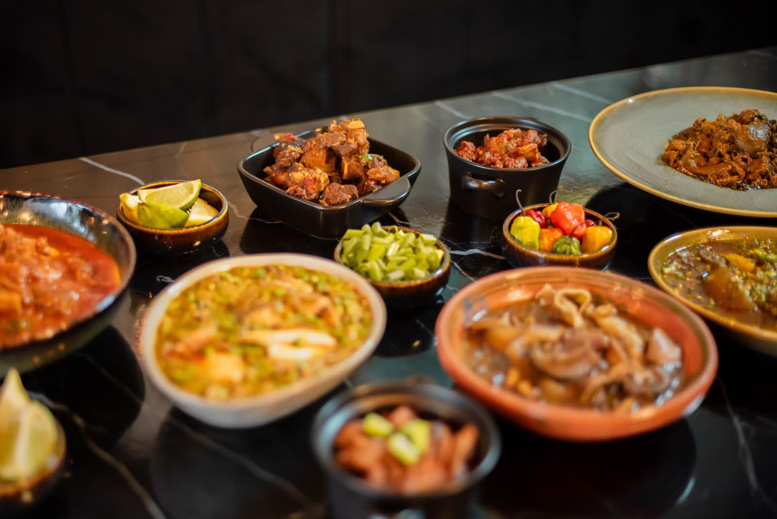 A long table set with a full spread of dishes under warm light