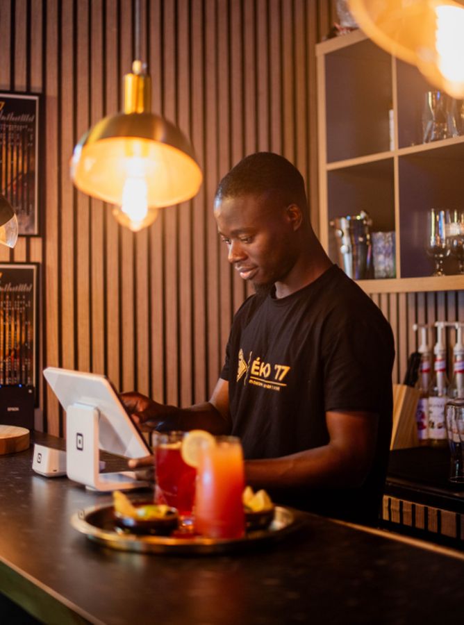 Behind the bar at ÉKO '77, a drink being mixed